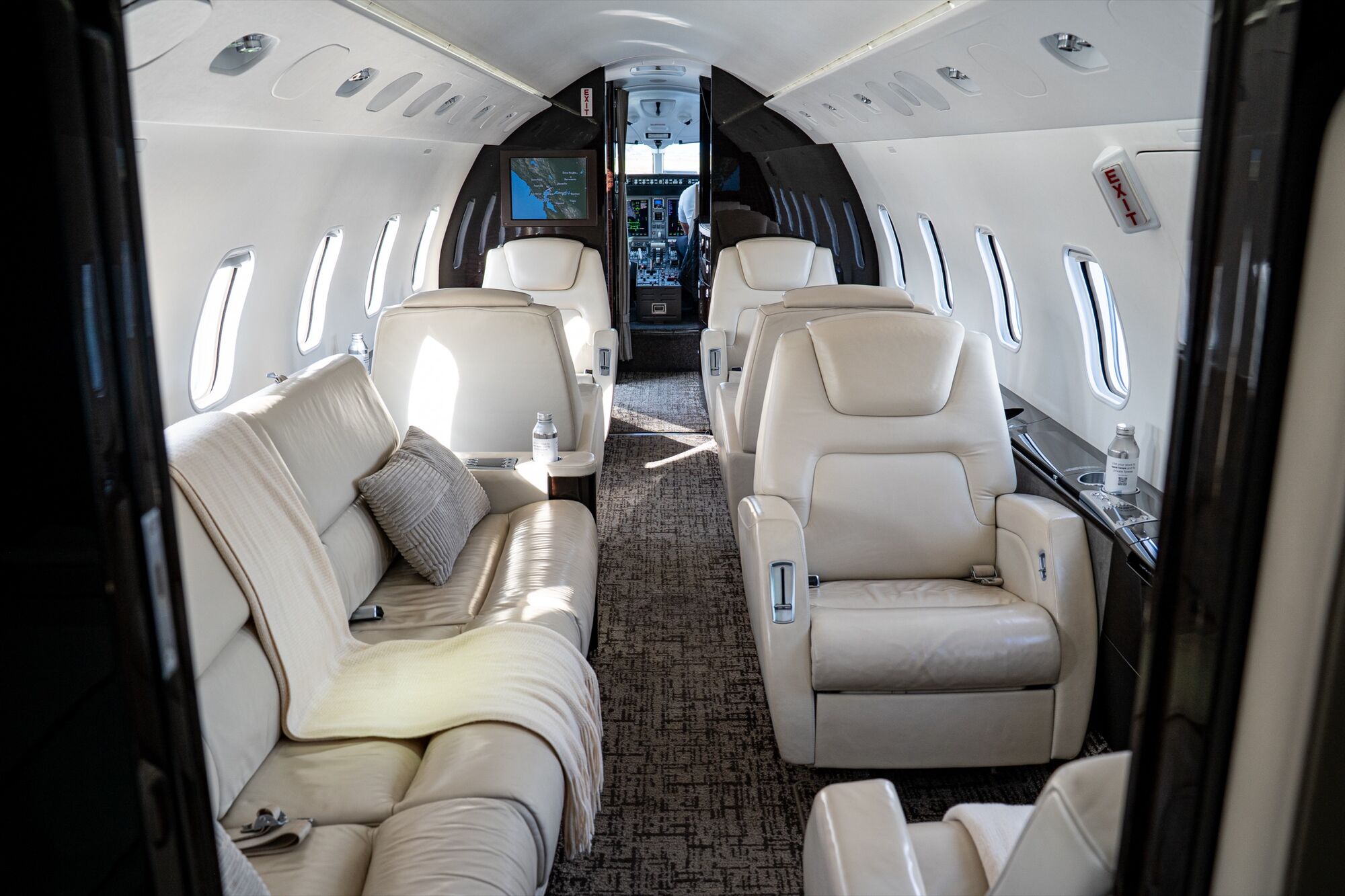The cabin of a CRAFT Challenger 300, with club seats and a divan