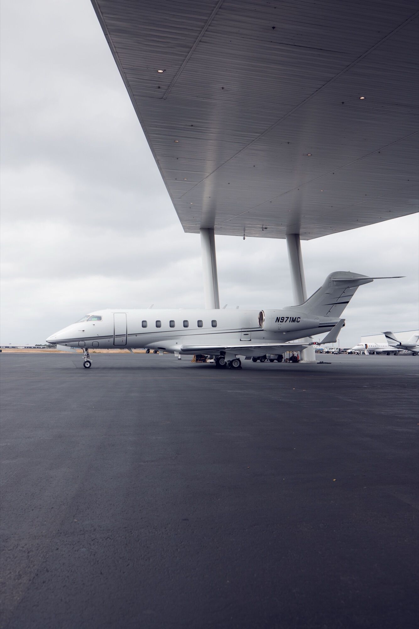 CRAFT Challenger 300 N971MC parked under the hangar canopy