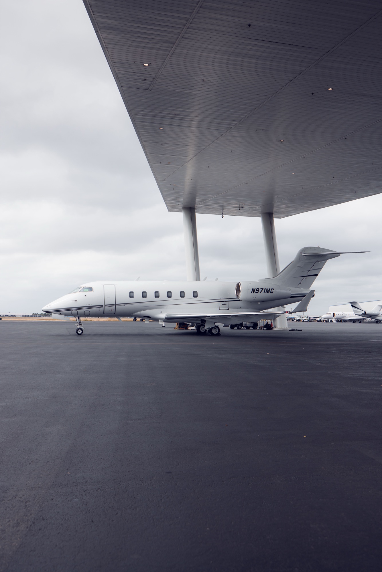 CRAFT Challenger 300 N971MC parked under the hangar canopy