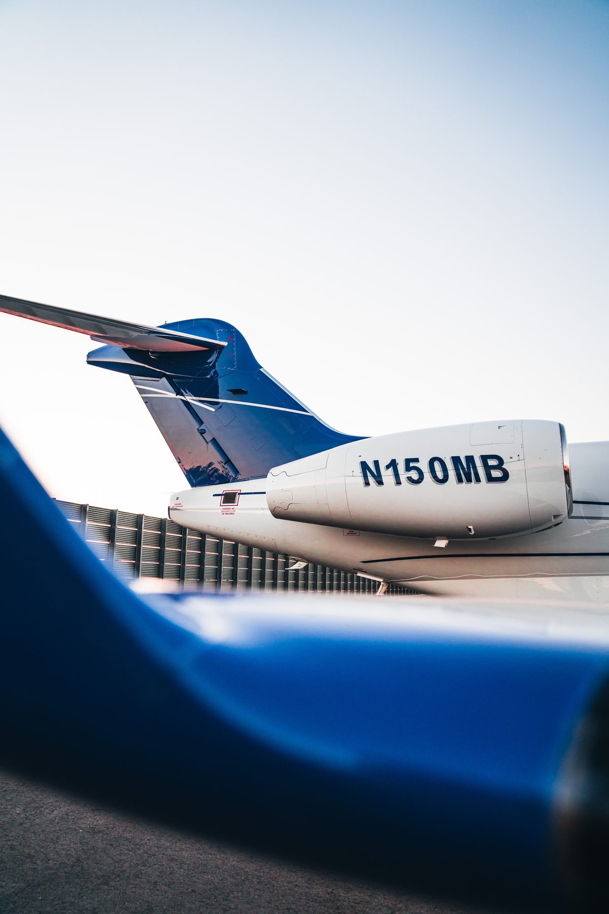 The tail and engine of CRAFT Challenger N150MB, seen past the winglet of a second aircraft