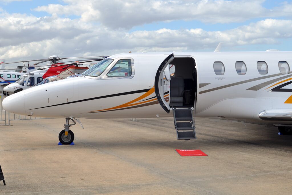 Cessna Citation CJ4 on ground with door open, stairs extended and red carpet