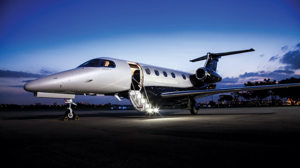 Embraer Phenom 300E exterior on ground with door open at sunset