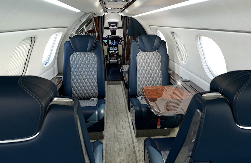 Embraer Phenom 300E interior cabin with blue and gray interior, window shades shut